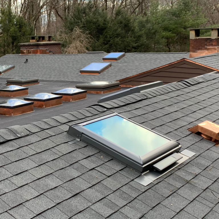 New asphalt roof installation with skylights and roof windows