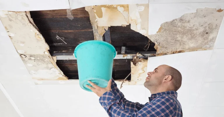 man dealing with ceiling leaks holding buckets