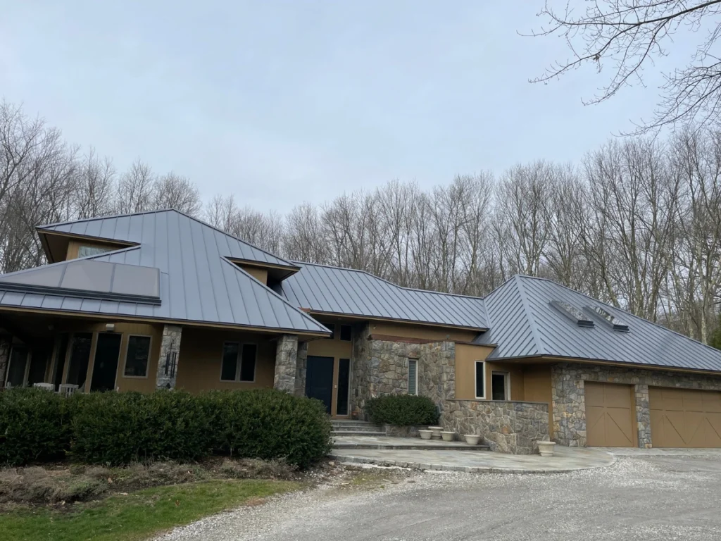 side view of custom fabricated metal roof with skylights on stone 1 level home