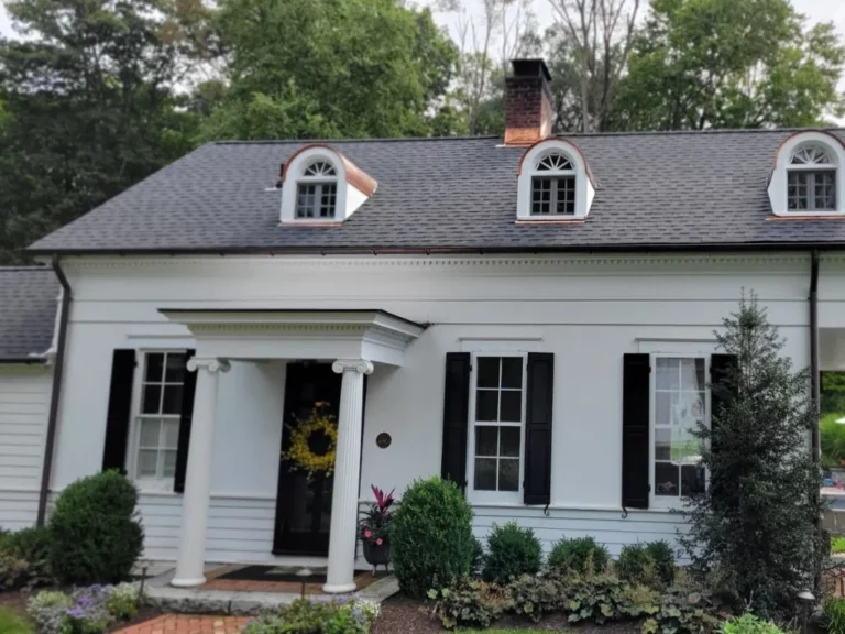 White house with grey shingle roof and copper flashing