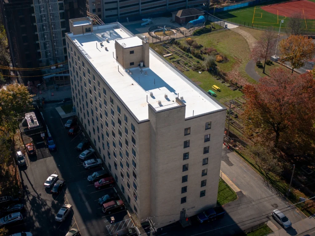 front side aerial view of a white TPO johns manville roof on residential building in new rochelle, NY