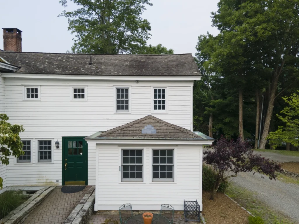 back of house showing old curling shingle roof in somers ny before replacement