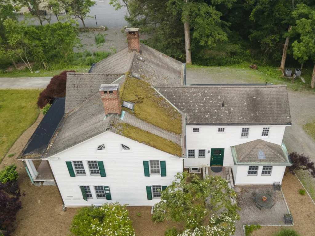 side of house showing moss covered roof old curling shingle roof in somers ny before replacement