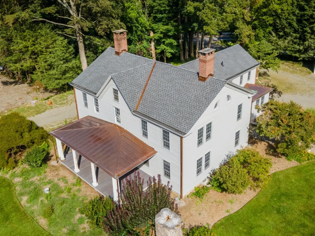 aerial view of light grey gaf roof replacement in somers ny with copper flashing and awnings