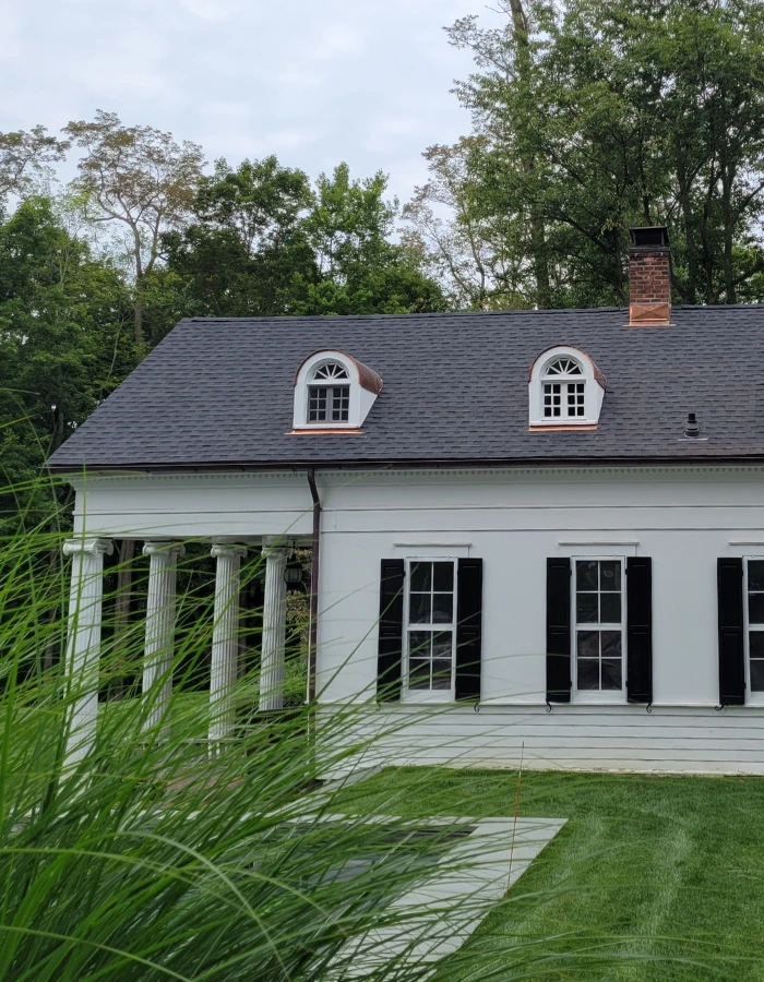 1 story house with white siding near new rochelle, NY after GAF roof replacement with grey roof shingles, copper roof flashing, and copper window dormers