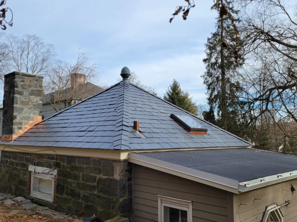 small structure with stone siding and synthetic slate roof shingles