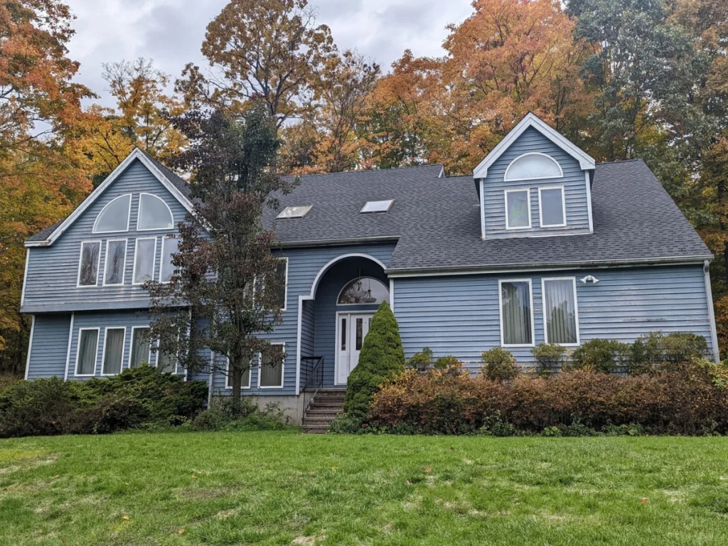 home with blue siding and a new medium grey shingle roo