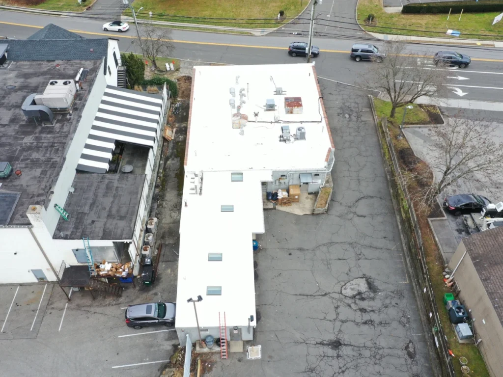 Aerial photograph of new flat white commercial roof on laundromat