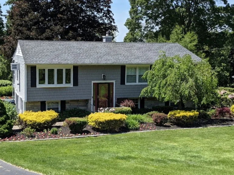 raised ranch near brewster ny with grey shingle roof and blueish grey siding