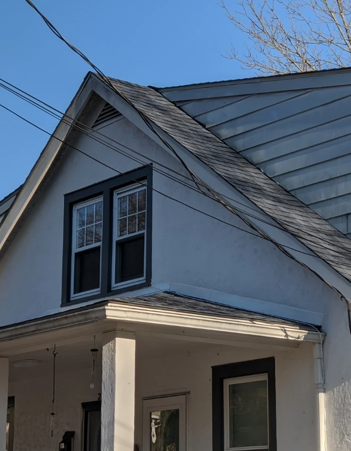 Split level home in Mamaroneck with new dark gray shingles on the main roof and lower roof section.