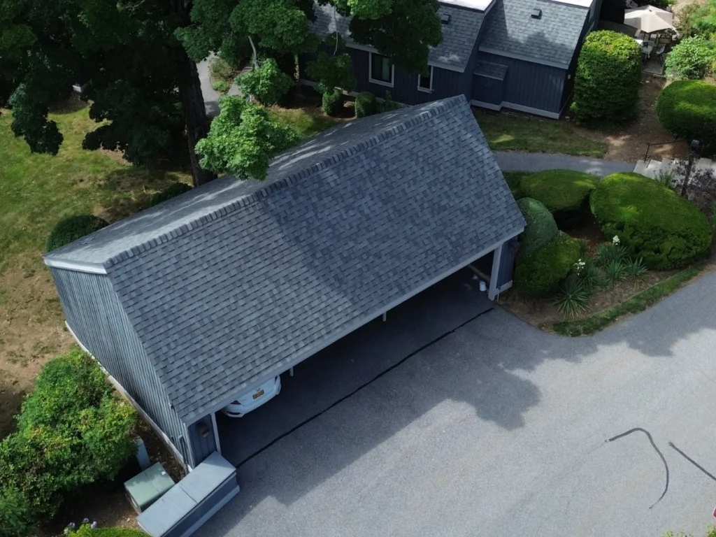 Residential carport in Mamaroneck with a steep, shingled roof.
