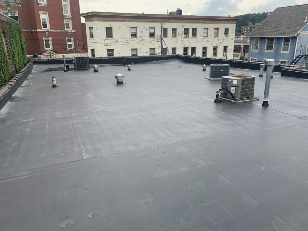 Flat black rubber roof on a low-rise commercial building with HVAC units.